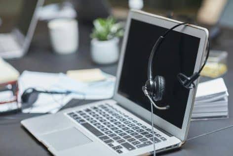 ia-contesta-llamadas-centralita-virtual Auriculares sobre un portátil para atención telefónica con centralita virtual